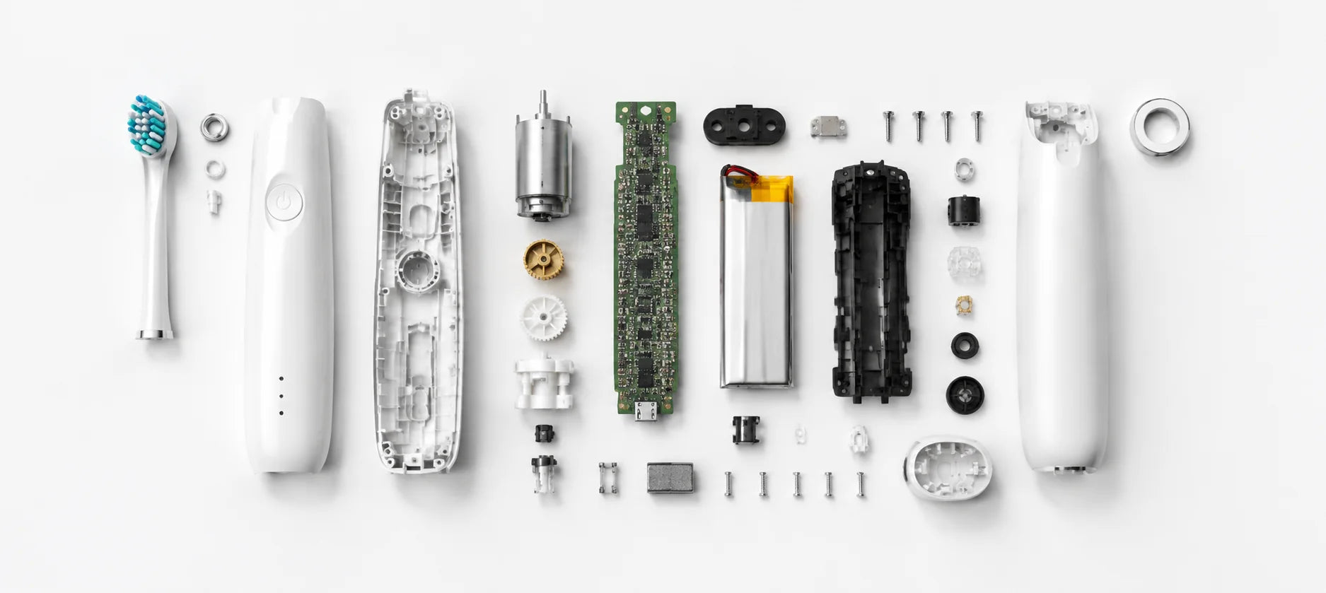 Teardown flat-lay of an electric toothbrush: head, housing, motor, gears, circuit board, battery and fasteners laid out in order